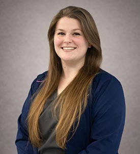Alexandra posing for a picture on grey background